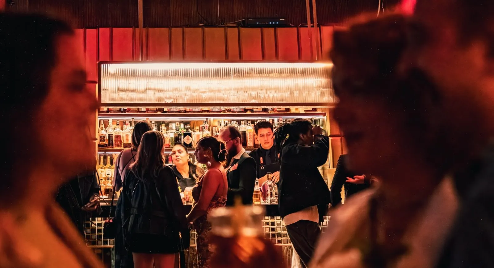 Guests gathered around an illuminated bar during a Green House on-premise activation for Brown-Forman.