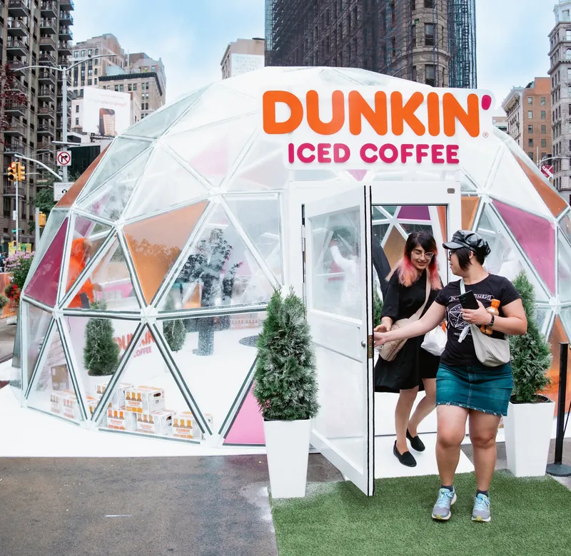 Consumers leaving a Dunkin' Iced Coffee igloo during a Green House experiential brand activation.