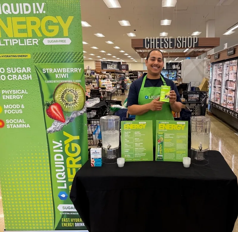 Green House brand ambassador hosting a Liquid I.V. Energy in-store sampling at a grocery store.